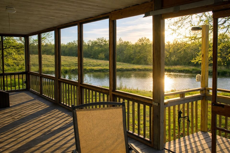 Peaceful pond views from the screened-in deck at Pond View Loft. Enjoy sunrise coffee or sunset reflections overlooking the fishing pond and open country landscape — a perfect spot to relax, unwind, and reconnect with nature.