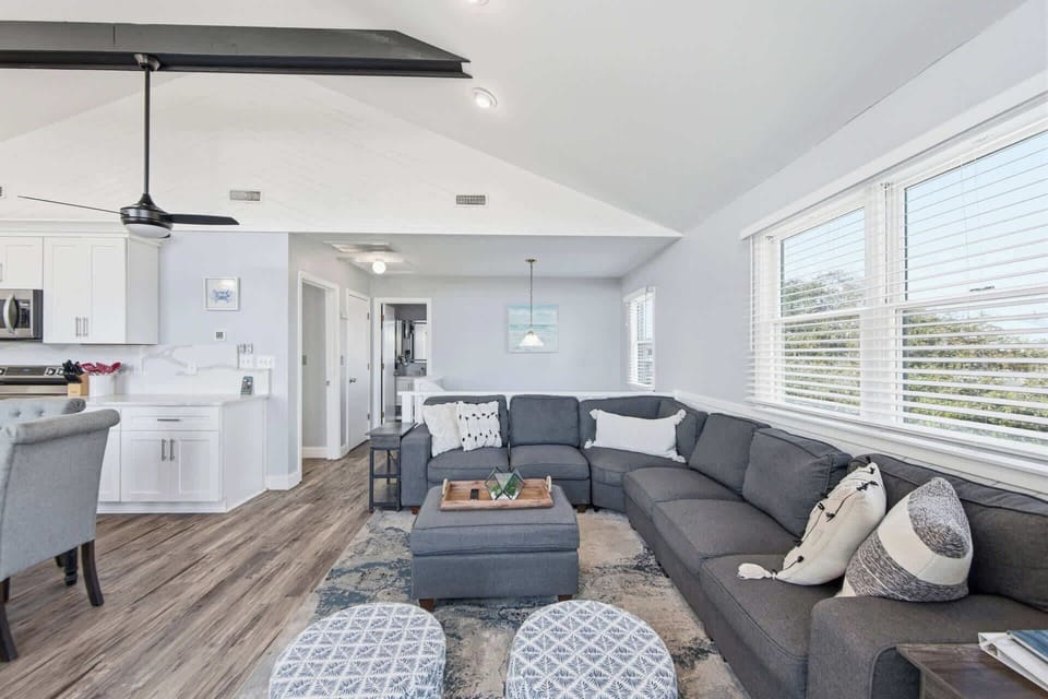 Bright and open living room featuring a large, comfortable sofa and TV - perfect for movie nights, game days, and relaxed evenings together