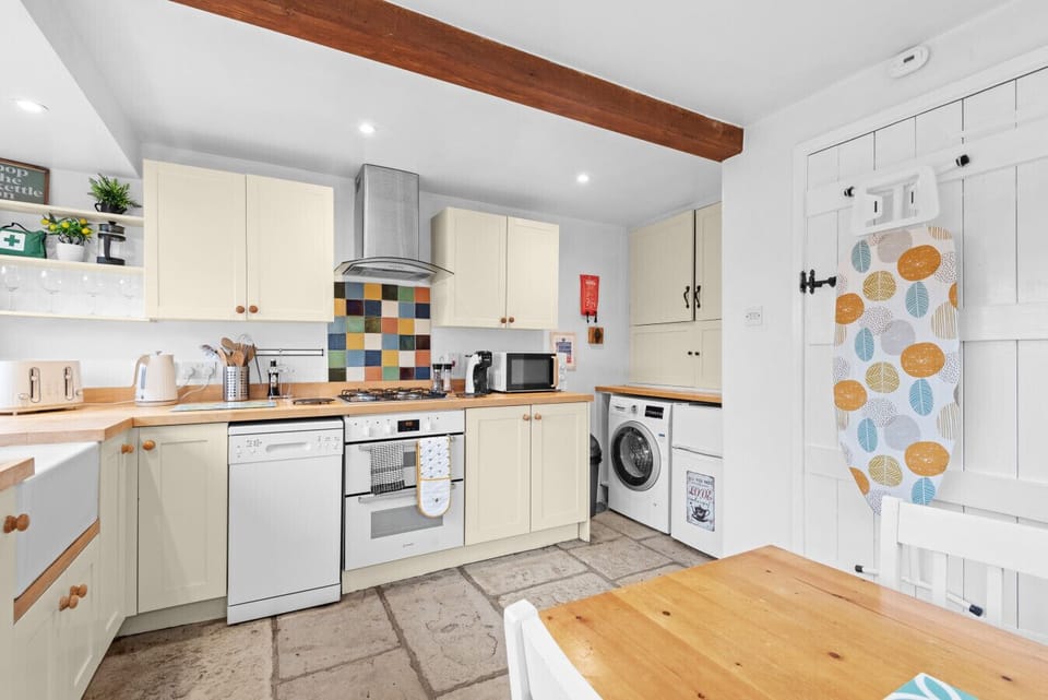 Fully equipped kitchen with modern appliances and rustic flooring