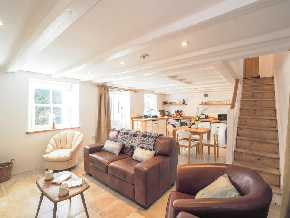 Coffee table, sofas, view into kitchen and up the stairs