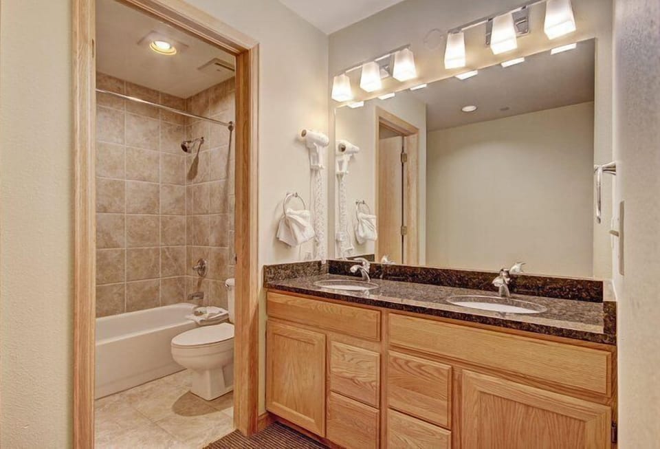 Well-appointed bathroom with a granite vanity, full tub, and bright lighting for a refreshing start or end to your day.