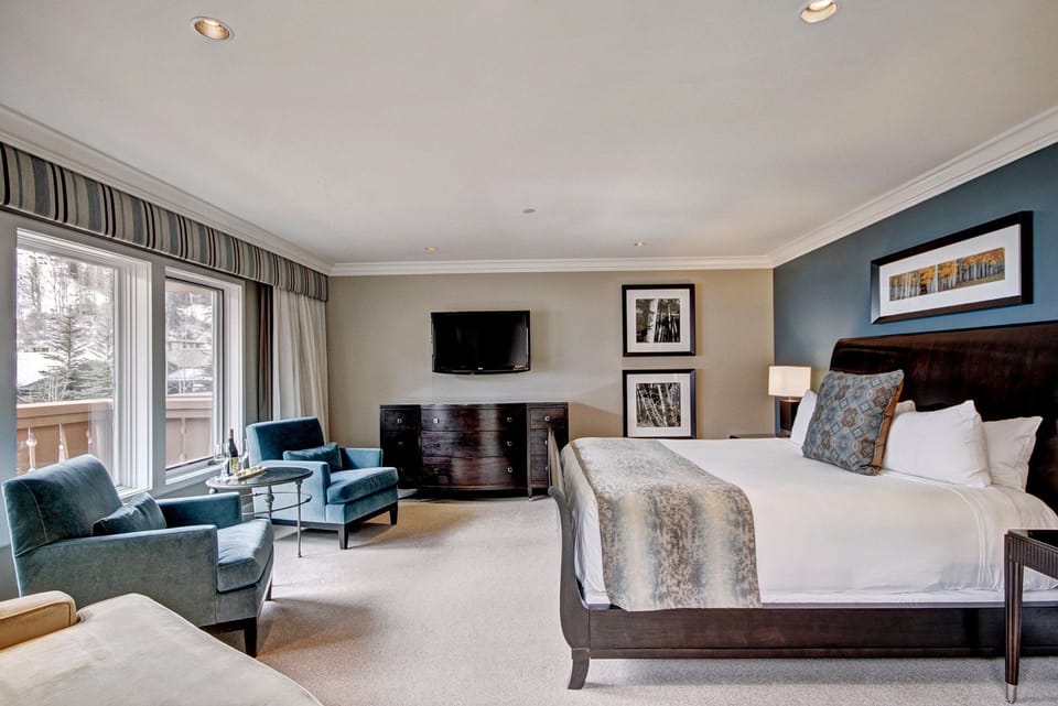 Enjoy breathtaking mountain views through expansive windows while relaxing in stylish armchairs in the cozy living area.