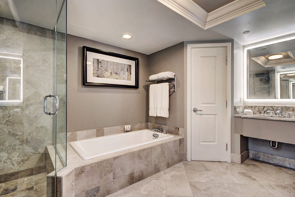 A luxurious bathroom awaits, featuring a spacious soaking tub and elegant stone finishes, ensuring the utmost comfort and relaxation.