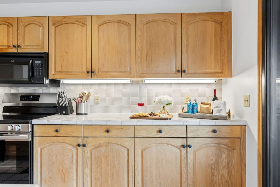 Kitchen: Drip coffee maker, Crockpot, blender, toaster, cooking utensils, tableware, bar seating for 3 at tiled island