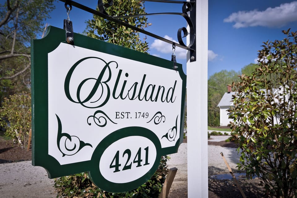 Historic Blisland entry sign—welcoming drive, manicured grounds.