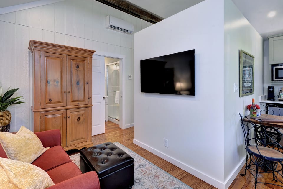 Cozy living area with smart TV, hardwood floors, and bistro dining