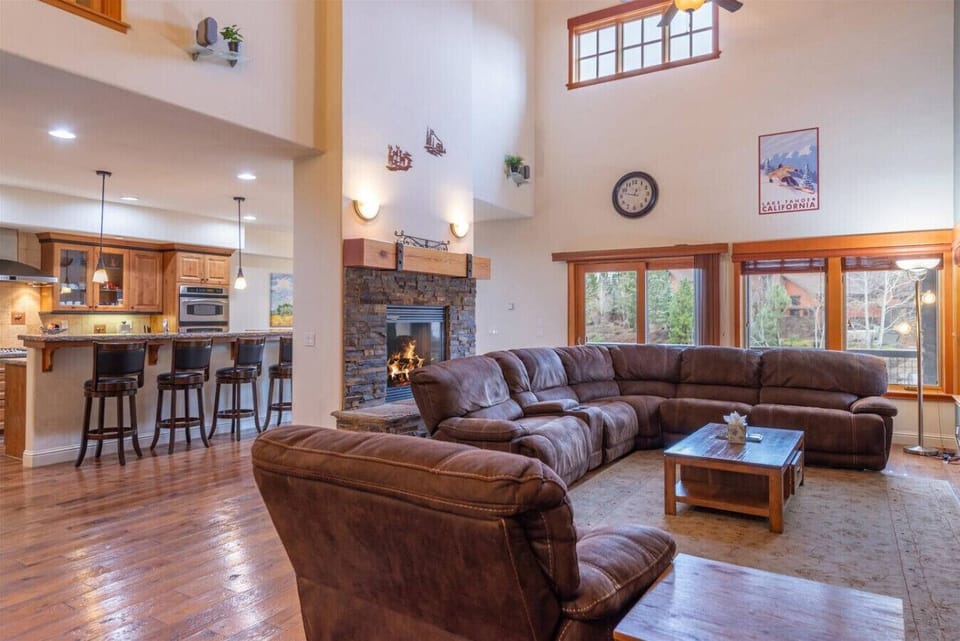 Spacious great room (living room, dining area, kitchen) with vaulted ceilings, see through gas fireplace, 65 inch SmartTV and comfortable furnishings.