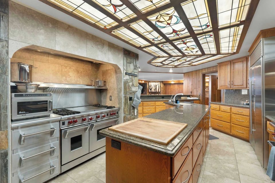 Residential kitchen with commercial level Wolf, Viking and Sub-Zero Apliances and unique stained glass lighted ceiling