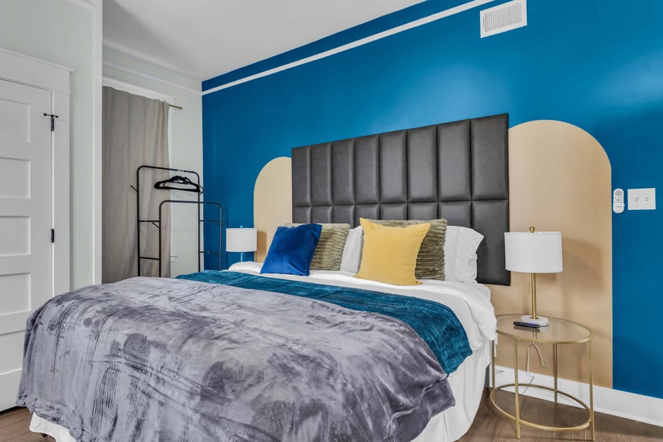 STYLE & COMFORT: Plush velvet headboard with blue accent wall! Turn bedtime into vacation luxury! Gold accents, chic design. Book now!