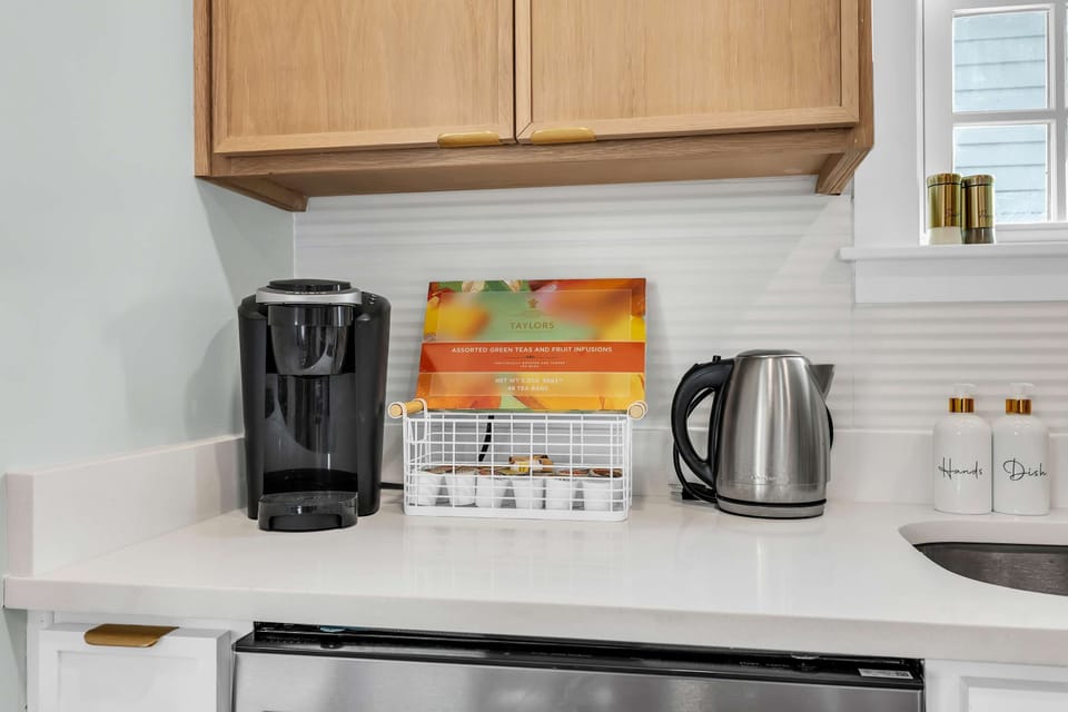 COFFEE & TEA STATION: Keurig & kettle for stress-free mornings! Turn daily routines into vacation delight! Assorted teas, modern appliances. Book your Savannah stay today! #CoffeeStation #TeaTime