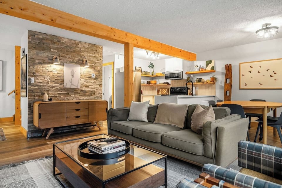 Main floor living room with a 55` Smart TV with cable, board games, cozy seating options, and a decorative fireplace for that cabin ambiance (3-hour glow logs only please!)