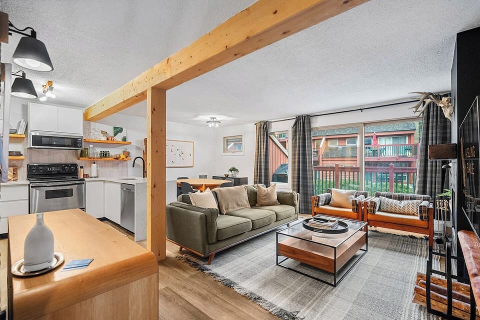 Main floor living room with a 55` Smart TV with cable, board games, cozy seating options, and a decorative fireplace for that cabin ambiance (3-hour glow logs only please!)