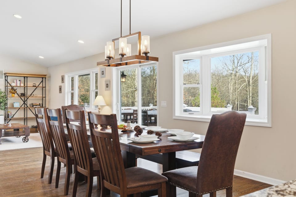 Dining space with seating for eight and bright windows.