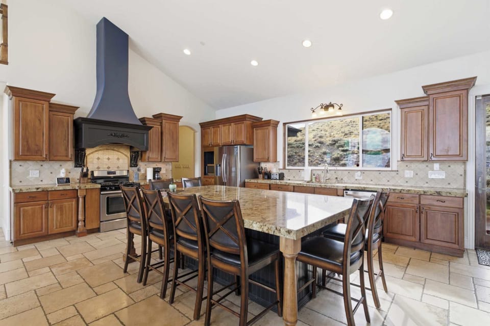 Gourmet kitchen featuring custom cabinetry and a statement range hood