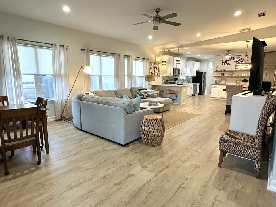 Light gray sectional, woven accents, and wood tones bring airy warmth.
