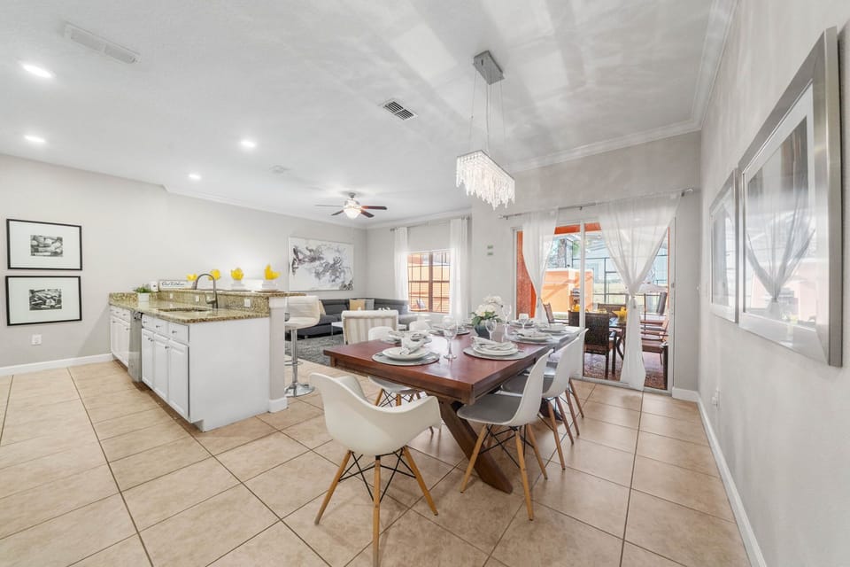 Airy open-plan flow: kitchen, dining, and lounge open to the screened patio and pool-easy entertaining for the whole group.