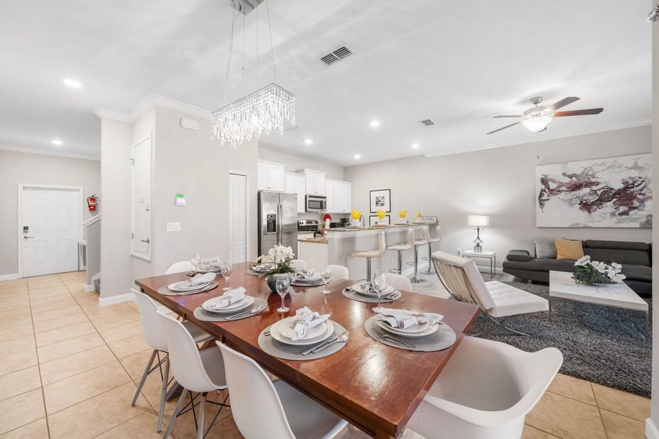 Bright open-concept living with chic chandelier, spacious dining area, granite breakfast bar, and cozy lounge-gather, cook, and relax together.