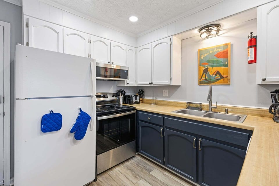 The updated kitchen features refreshed cabinetry, new appliances, and everything needed to prepare meals during your stay.