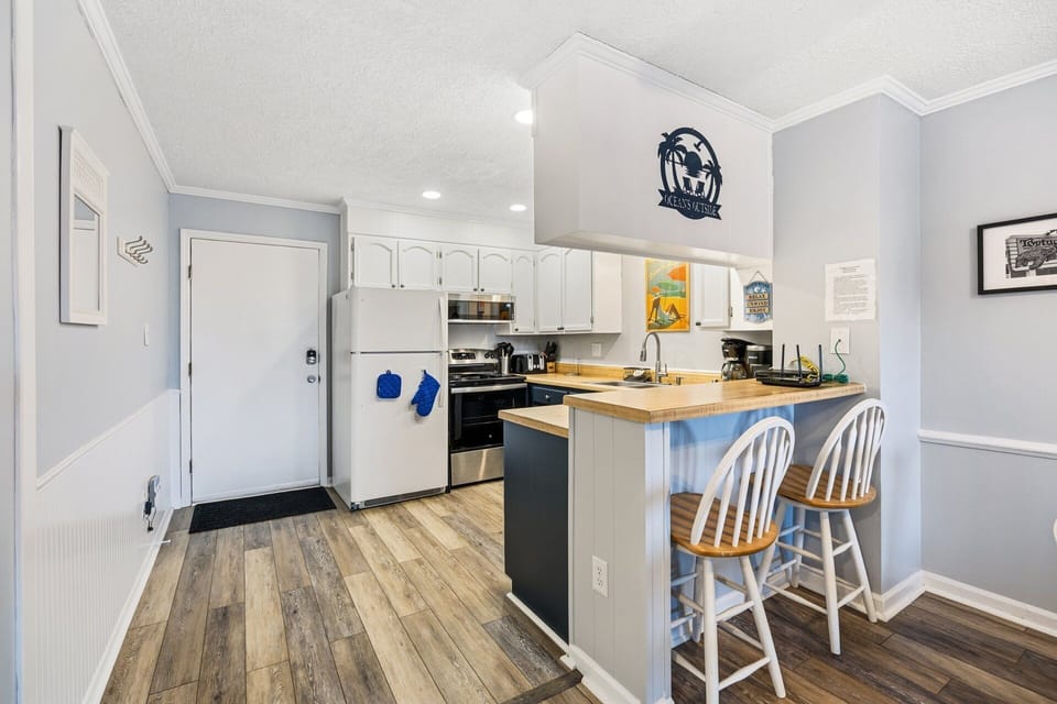The updated kitchen features refreshed cabinetry, new appliances, and everything needed to prepare meals during your stay.