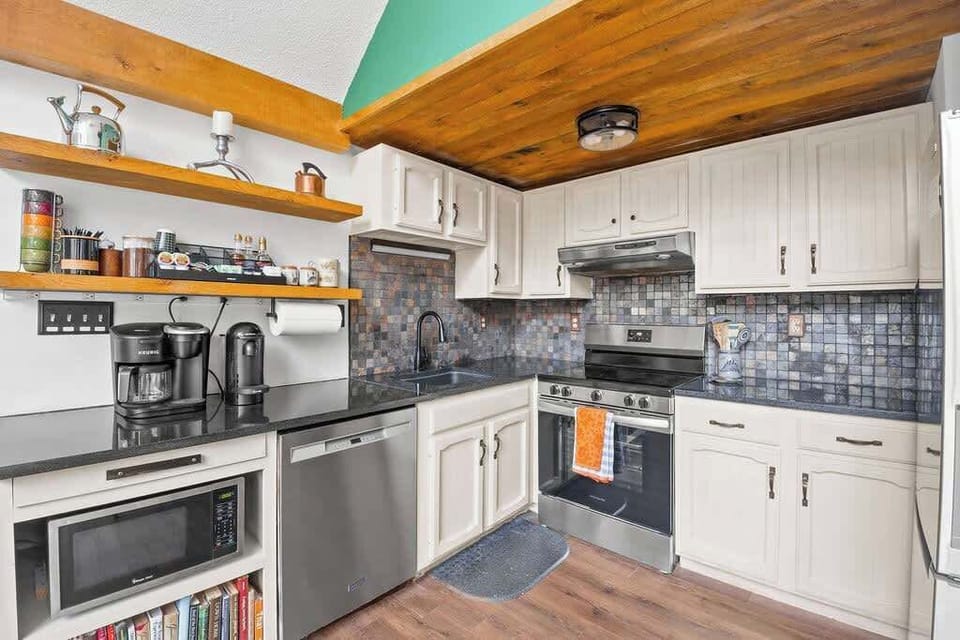 Kitchen with sleek countertops, open shelving, and everything you need for home-cooked meals.