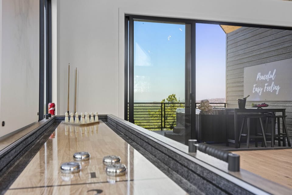 Shuffleboard and bowling pins set up with a view of the deck — game room hangs at Eagle`s Vista don`t disappoint.