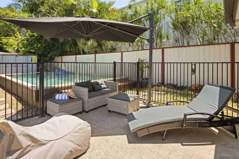 A shaded poolside retreat with loungers and comfortable seating—perfect for relaxed summer days.