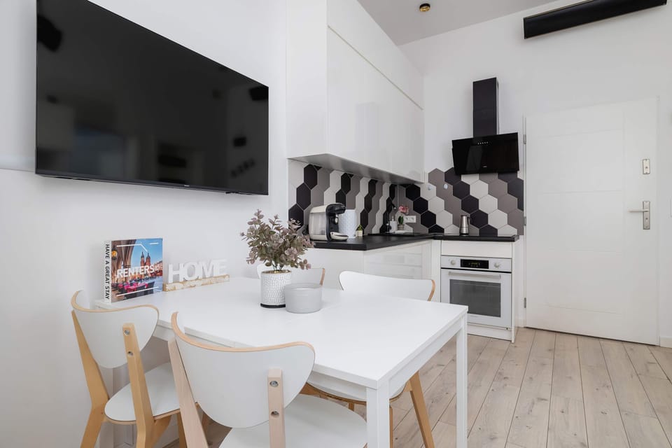 Contemporary kitchen area showcasing striking black-and-white geometric tiles, sleek cabinetry and modern built-in appliances.