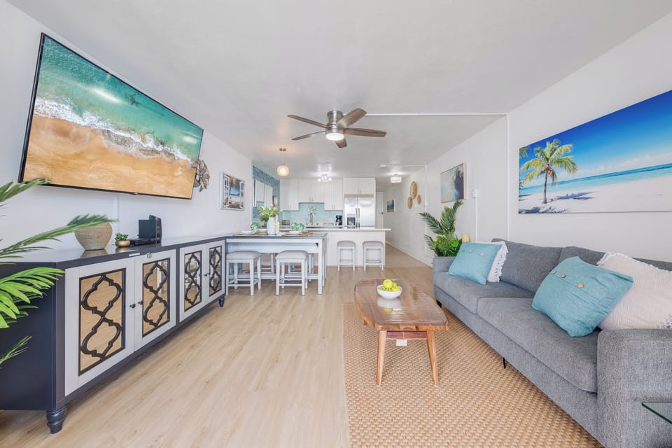 Stylish living room with modern furnishings and coastal artwork, ideal for relaxing after a day at the beach.