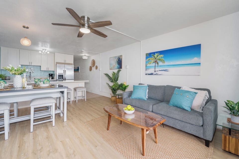 Spacious open-concept living area featuring tropical decor and natural lighting for a welcoming atmosphere.