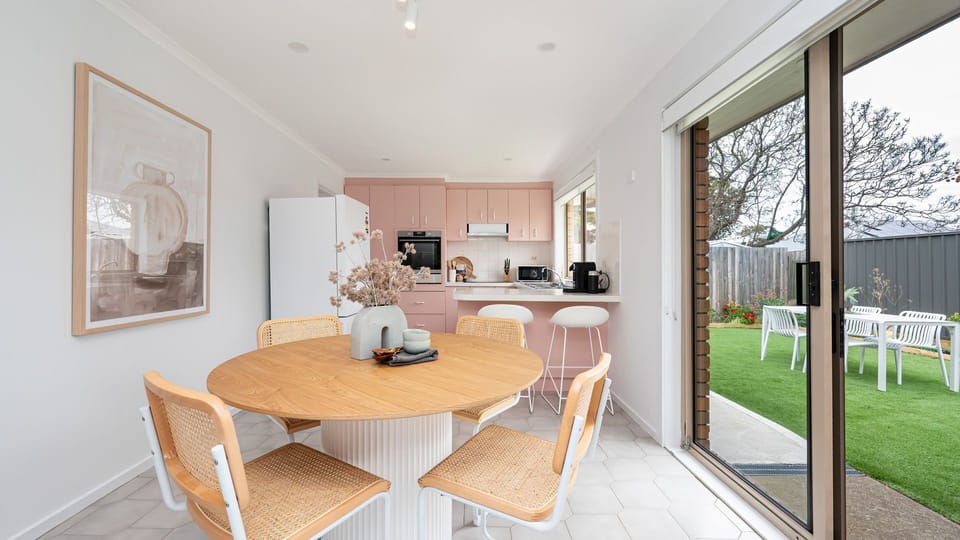 Open space Kitchen with dining table and sliding doors to outside garden