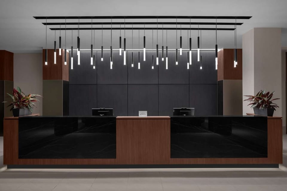 Front desk with black panels and hanging lights above