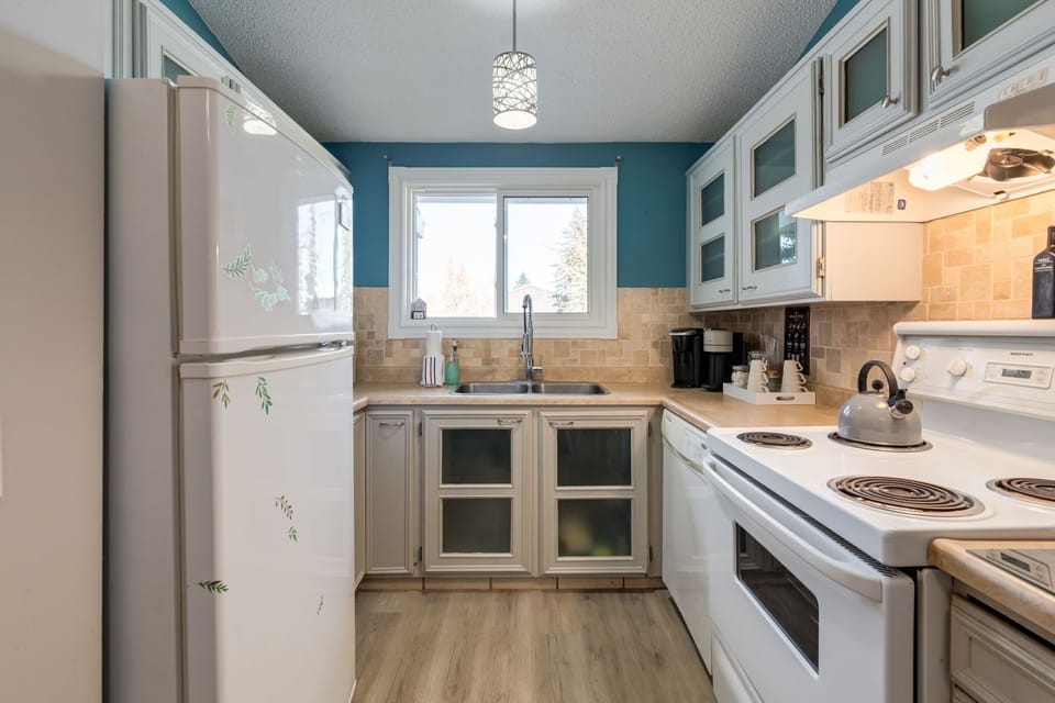 Charming kitchen with shaker cabinetry, glass uppers, and full appliances