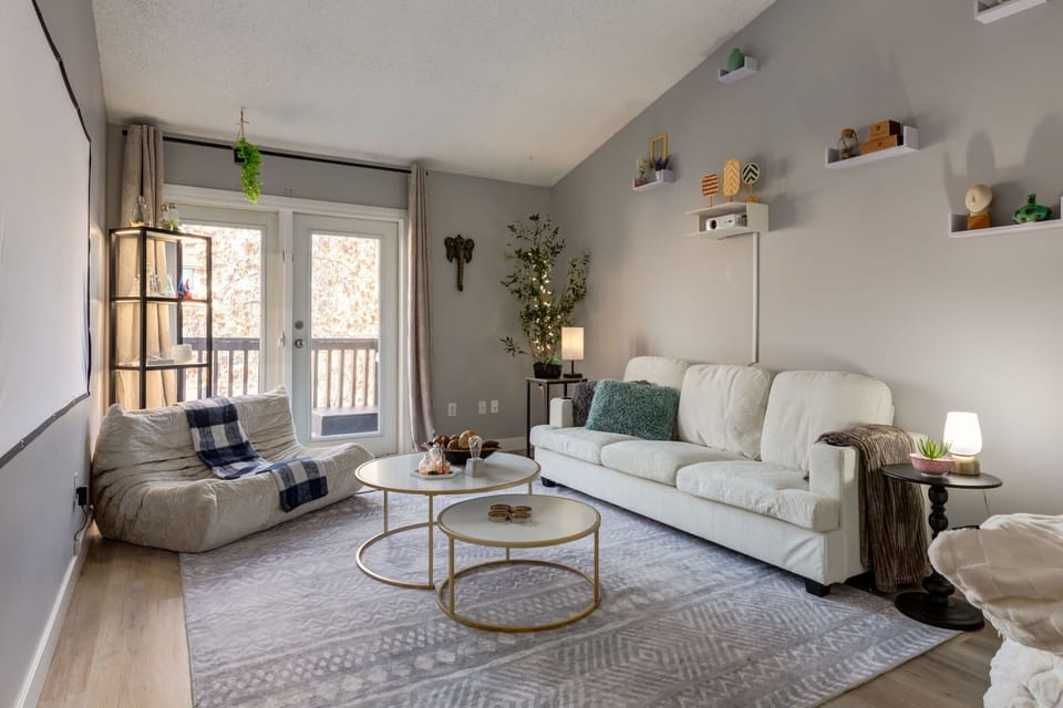 Bright living room with vaulted ceilings and projector for movie nights