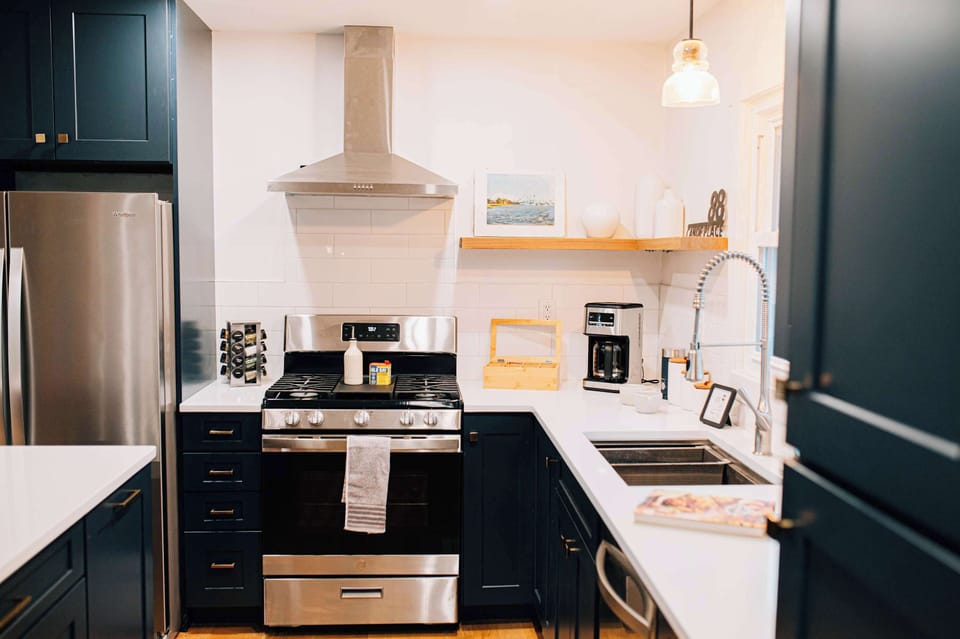 A beautifully updated kitchen with sleek appliances, open shelving, and everything you need for easy family meals. Bright light and thoughtful details make cooking feel simple and inviting throughout your stay