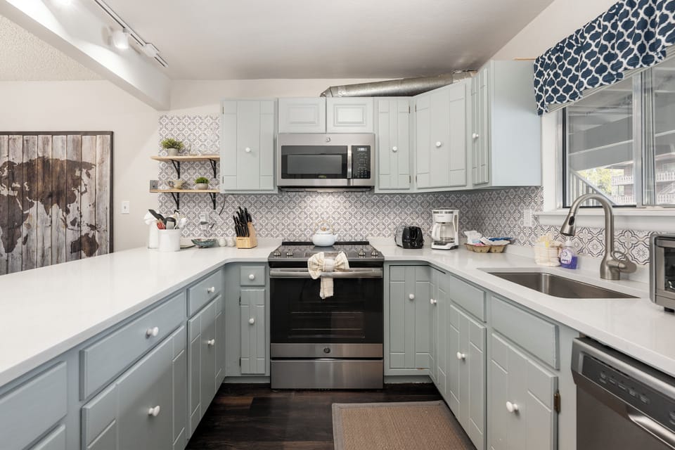 Your fully equipped kitchen features modern appliances and charming two-tone cabinets, perfect for preparing meals during your stay.