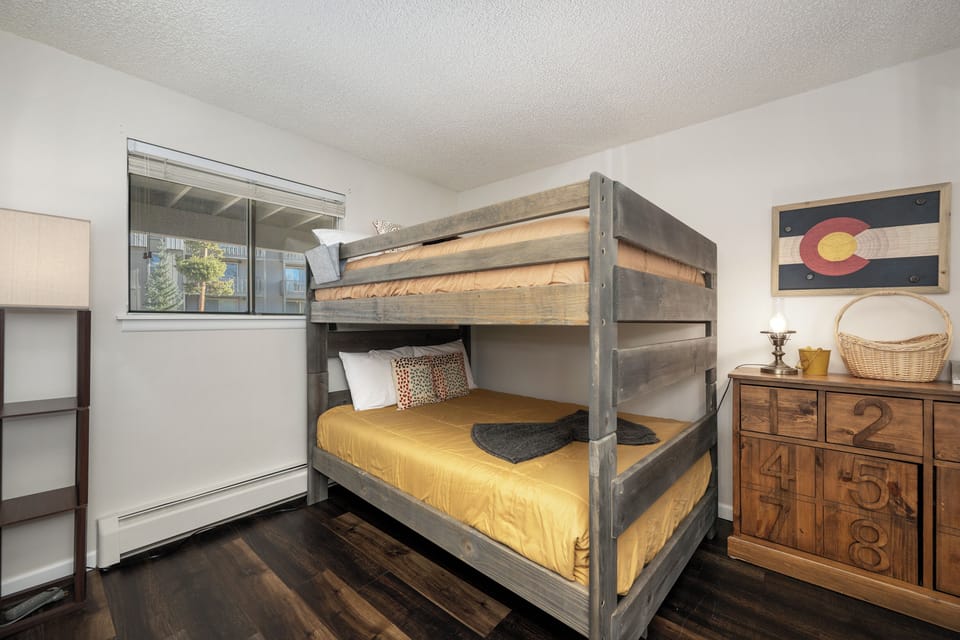 Cozy bunk room with rustic wood beds and mountain-themed decor creates the perfect adventure basecamp for your group.