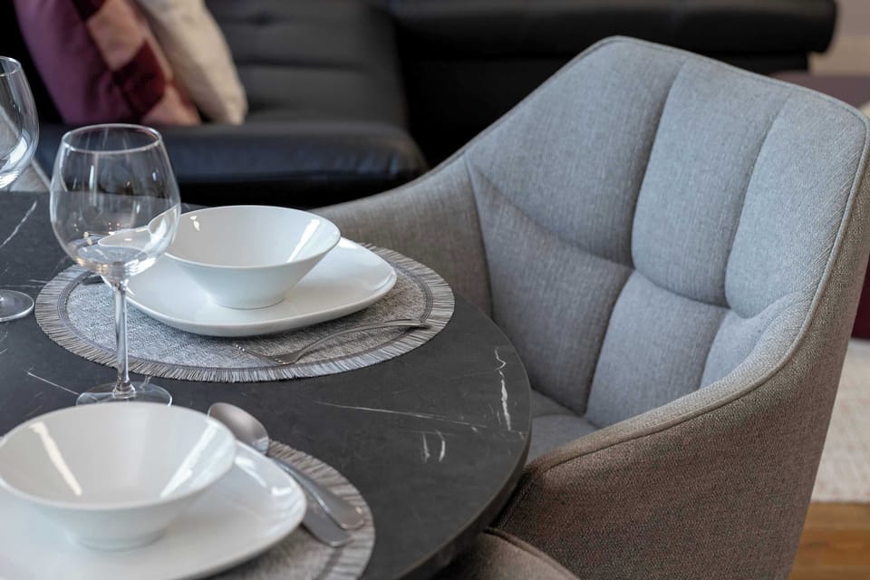 Dining setup with elegant tableware and comfortable chairs.