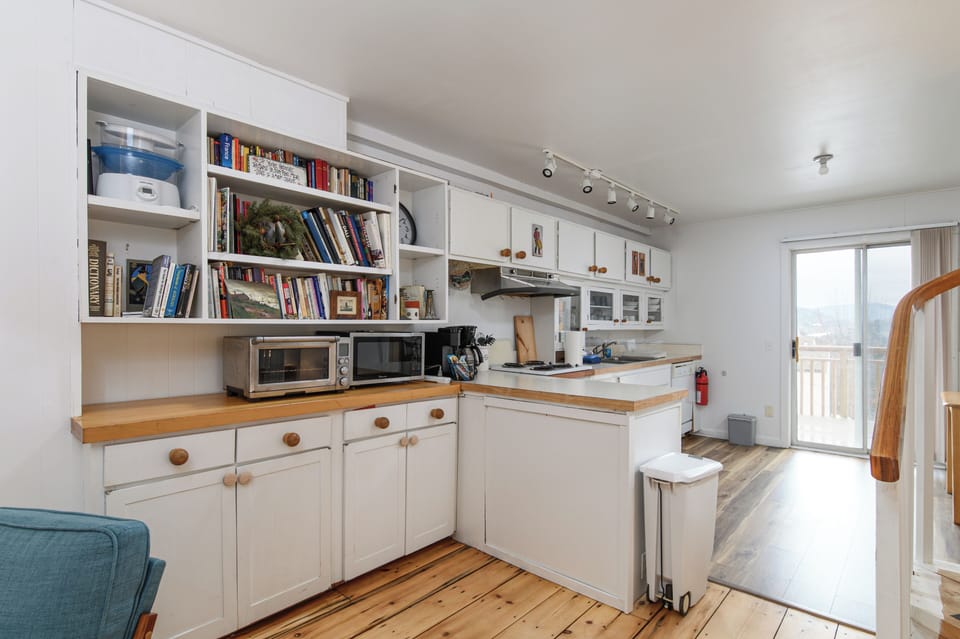 Cook and chat in a bright kitchen with a cooktop, toaster oven, and storage.