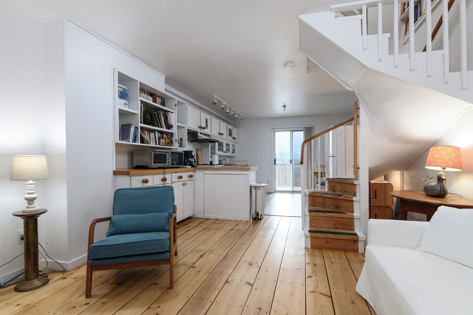 Settle into this two-level retreat with warm hardwood floors, built-in bookshelves, and bright kitchen, perfect for morning coffee.