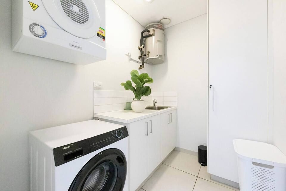 A full laundry with a washer, dryer, storage and cleaning essentials supports longer visits.