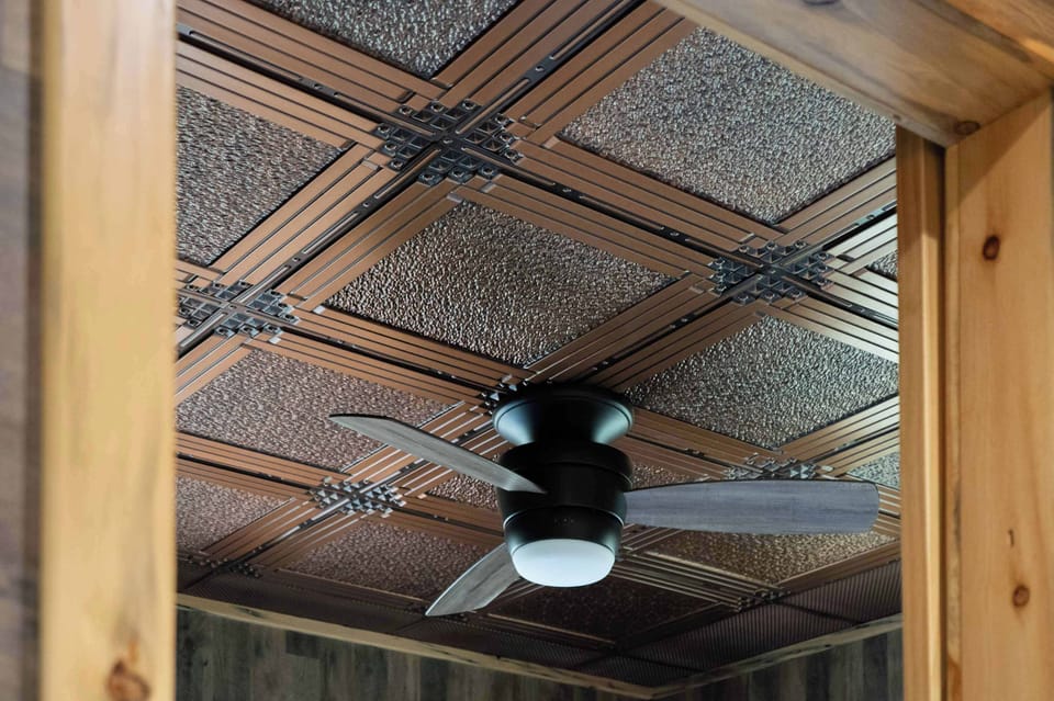 Look up to the handcrafted tin ceiling and warm wood details