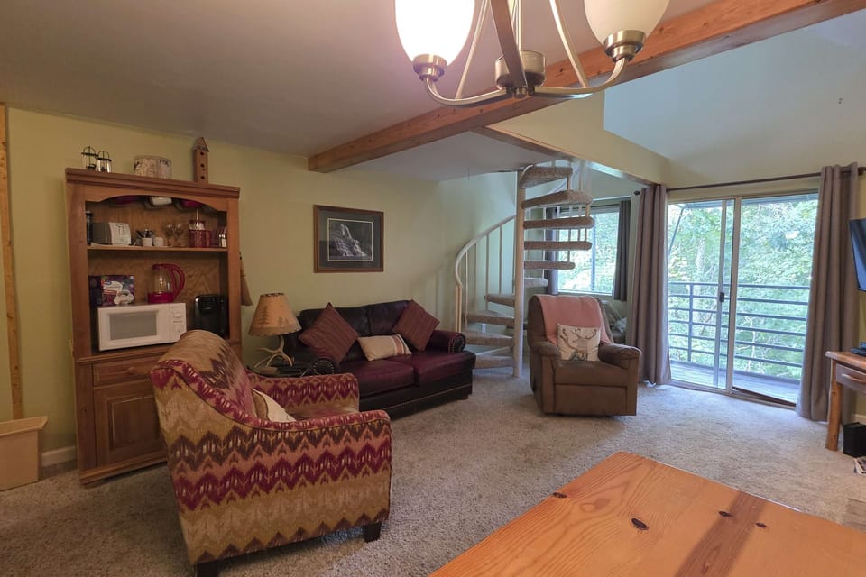 Living room retreat awaits. And, enjoy nature views through large windows and unwind on plush seating!