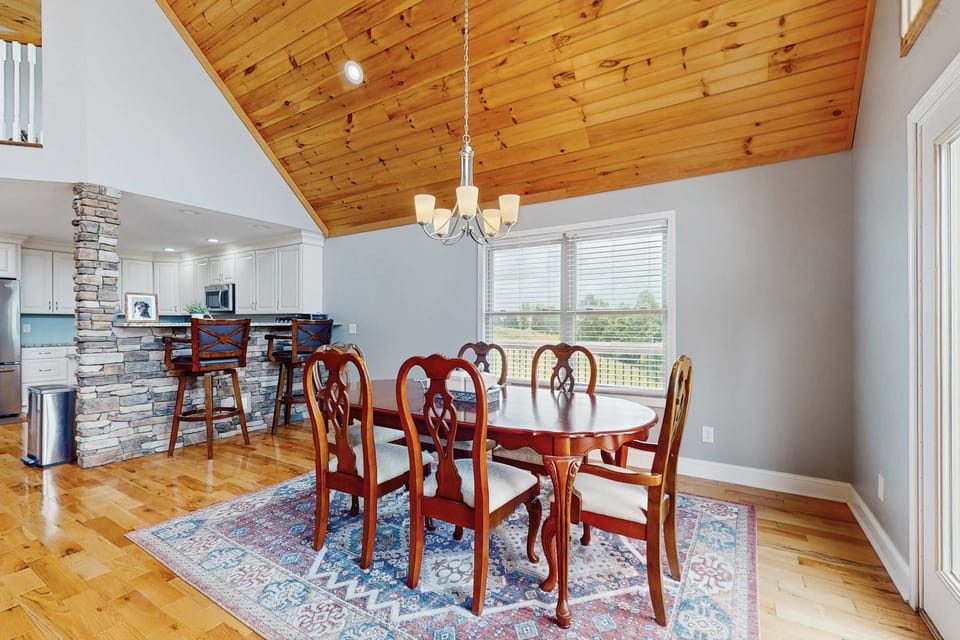 Elegant wooden table with chic chairs, surrounded by scenic views for memorable meals!