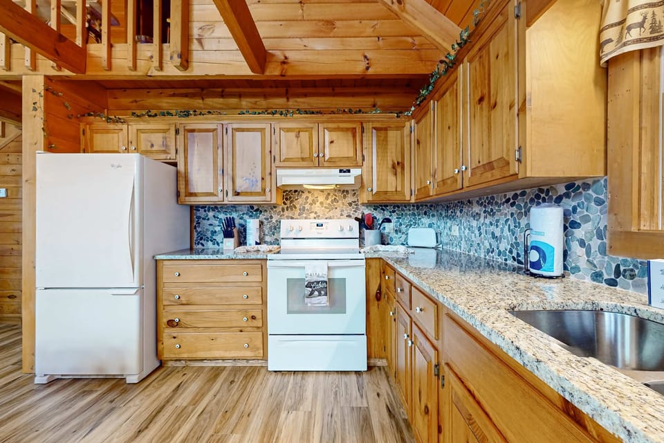 Modern appliances shine against natural wood and stone accents for flavorful family meals!