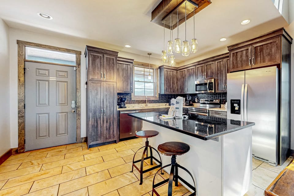Fully equipped kitchen with bar seating, stainless appliances, and spacious layout. Perfect for extended stays, family trips, and home-cooked meals.