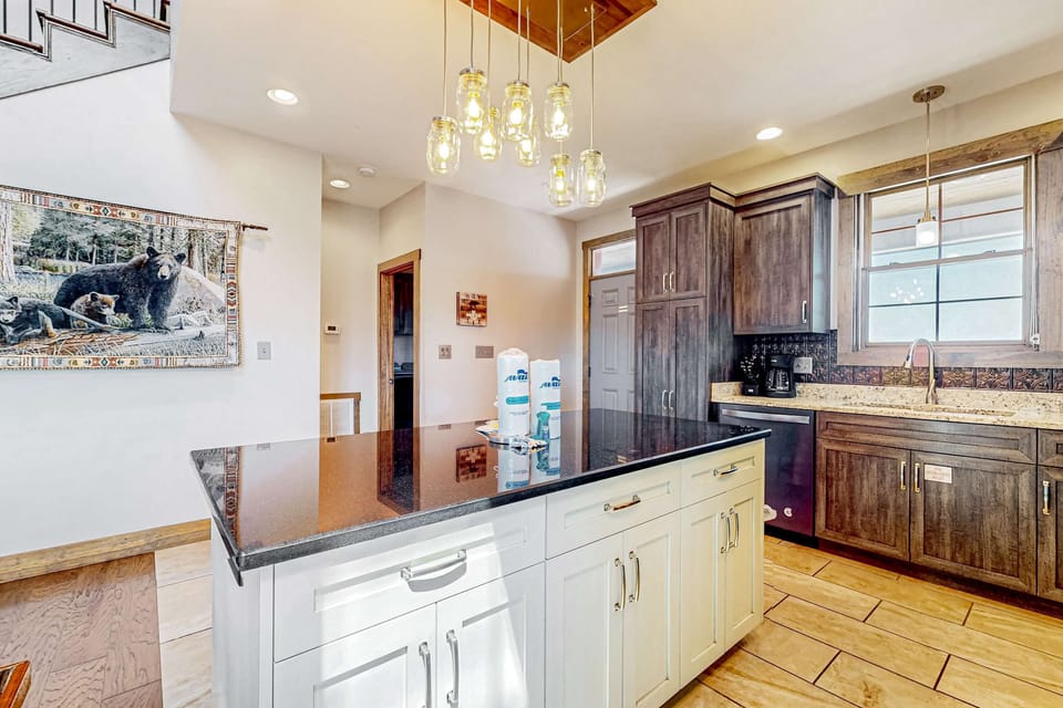 Modern farmhouse kitchen with a large island, upgraded lighting, and plenty of prep space. Ideal for cooking meals and hosting family dinners in the cabin.