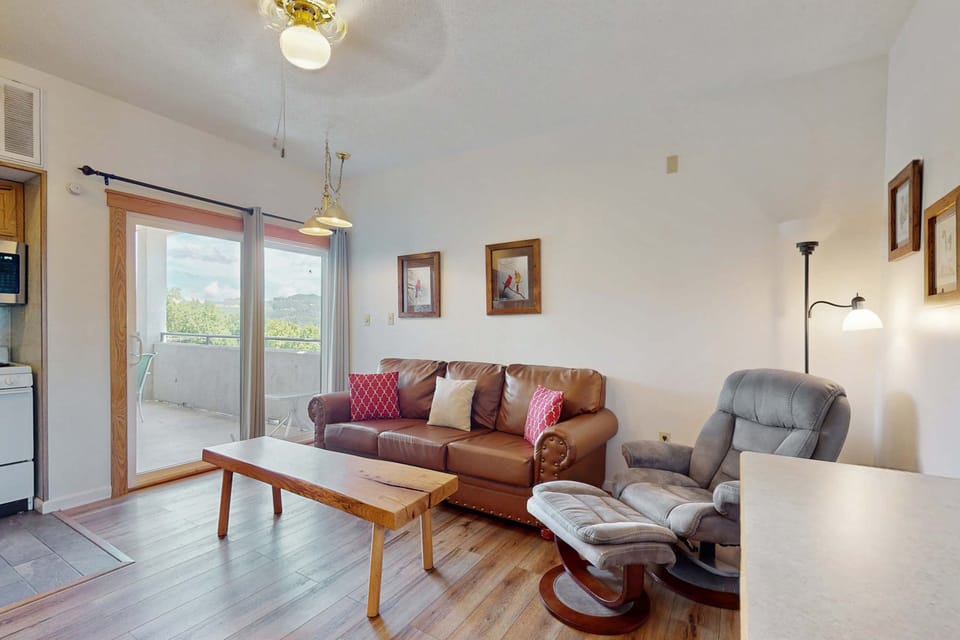 Sunlit haven with stunning views, plush seating, and a charming wood table for gatherings!
