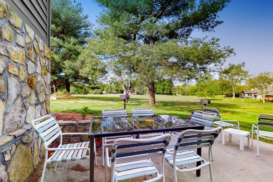 Shared outdoor patio with table seating, perfect for meals, games & relaxing. Family-friendly escape, group hangout, picnic vibe, peaceful grounds, and near attractions.