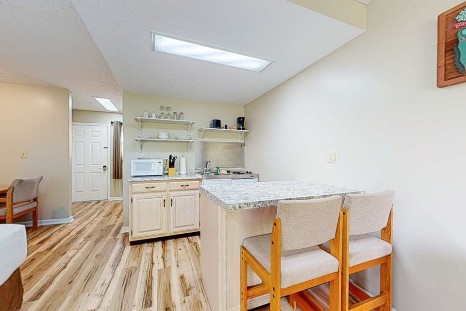 Dining island with bar seating, perfect for breakfast, remote work & quick meals. Extended-stay studio, clean modern layout, long stays, work travel, easy self check-in.