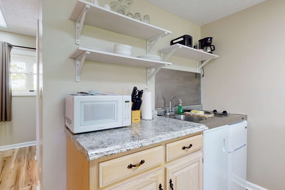Stocked kitchenette with microwave, mini-fridge, sink, dishes & coffee maker. Easy meals anytime. 